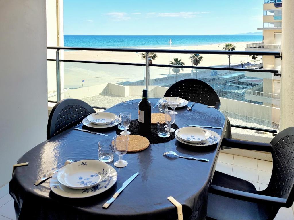 - une table avec une bouteille de vin et des verres sur un balcon dans l'établissement Canet-en-Roussillon - Studio alcôve 4 pers - Terrasse - Parking privé - FR-1-794-138, à Canet