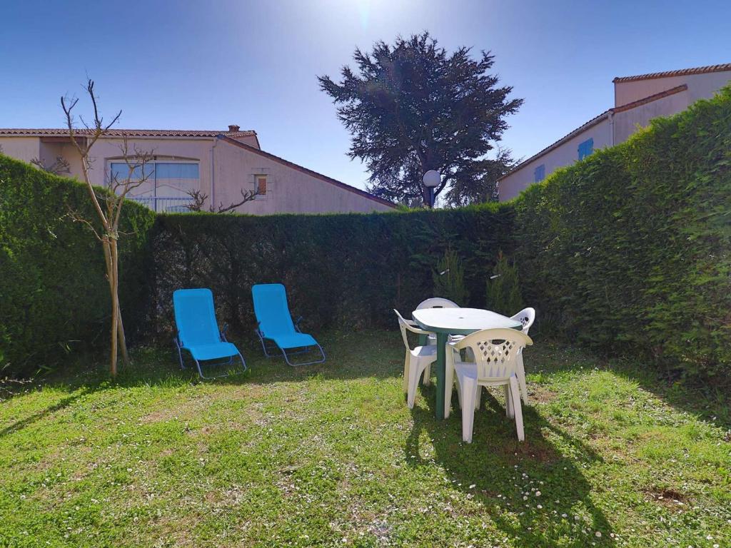 2 chaises, une table et 2 chaises dans la cour dans l'établissement Charmant appartement avec jardin, proche plages, commerces et Royan, parking privé - FR-1-494-195, à Saint-Georges-de-Didonne