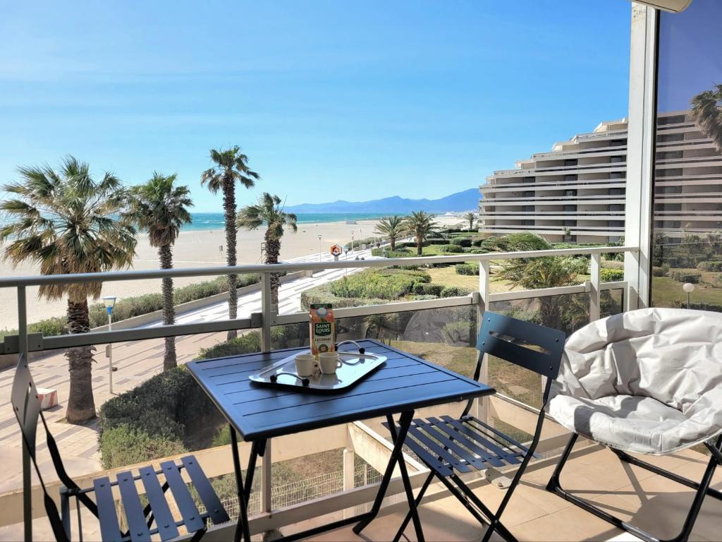 una mesa azul y sillas en un balcón con playa en Canet-en-Roussillon T2 Moderne - Parking - Clim - 2ème étage avec ascenseur - 4 pers - FR-1-794-136, en Canet-en-Roussillon