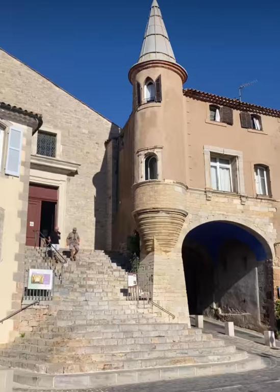 un bâtiment avec une tour et des escaliers devant dans l'établissement Chambre d Hôtes de charme, Coeur de la vieille Ville, à Hyères