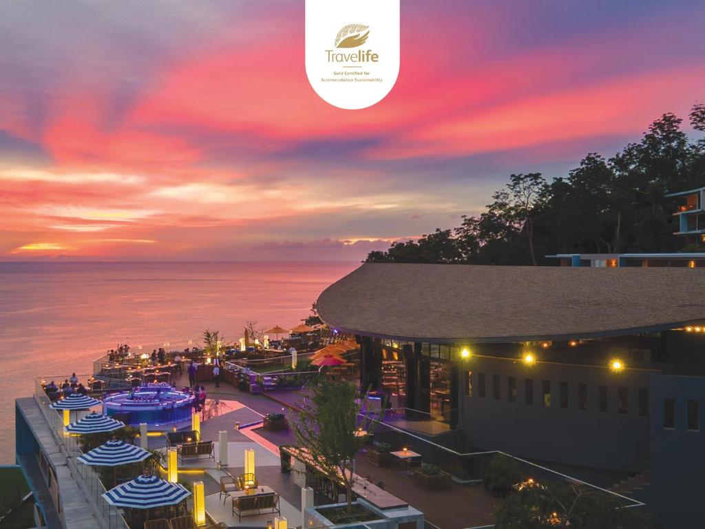 uma vista aérea de um resort com um pôr-do-sol em Kalima Resort and Spa - SHA Extra Plus em Praia de Patong