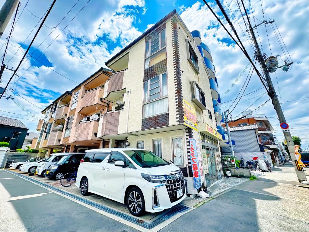 ein weißes Auto, das vor einem Gebäude geparkt ist in der Unterkunft 大阪民泊ー和の家 in Osaka