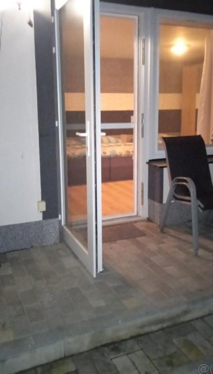 een glazen schuifdeur naar een kamer met een slaapkamer bij Liliana in Kaluža