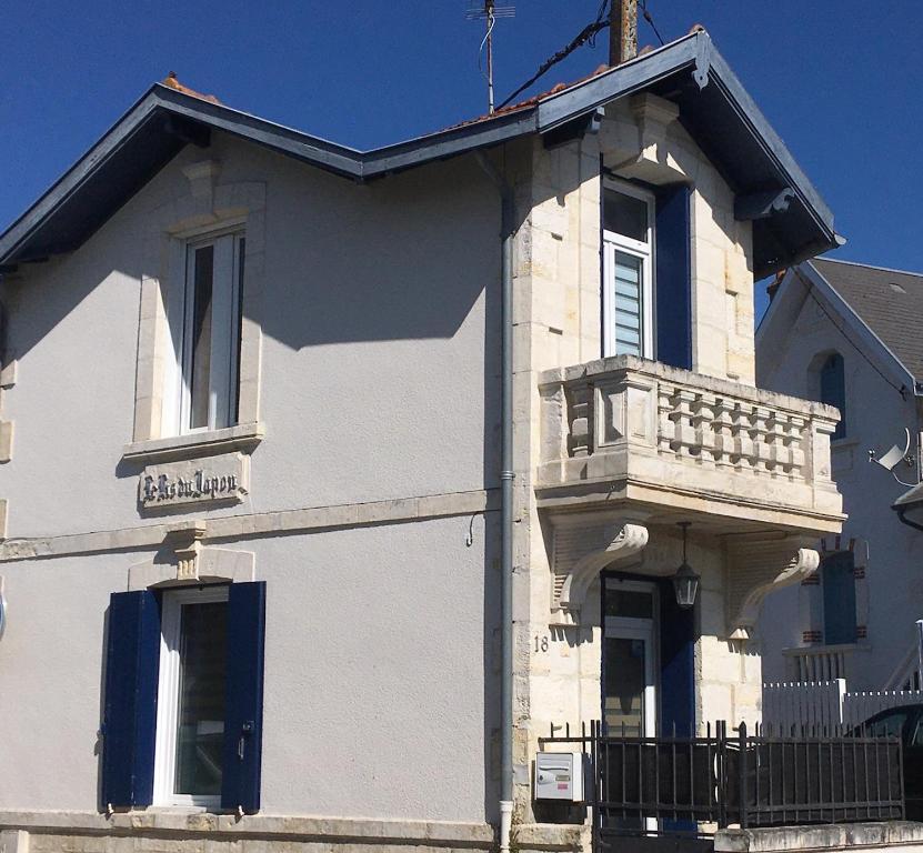 Cette maison blanche dispose d'un balcon sur le côté. dans l'établissement Lis du Japon, à Saint-Georges-de-Didonne
