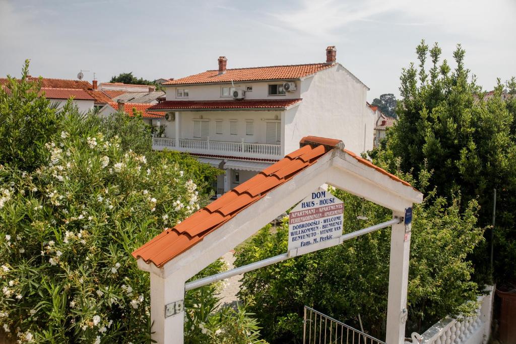 a building with a sign in front of a house at Apartment Daisy- excellent location close to Rab in Rab