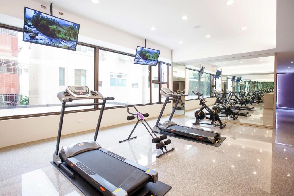 a gym with a row of treadms and cardio machines at Tsun Huang Hotel in Chiayi City
