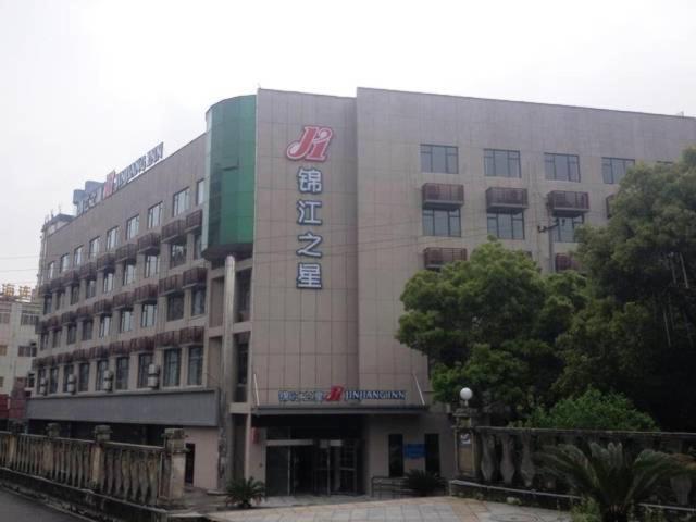a building with a sign on the side of it at Jinjiang Inn Jiujiang Internation Exhibition Center in Jiujiang