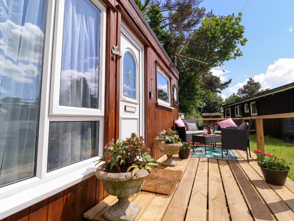 a porch of a tiny house with plants on it at Chalet Forte in Aberdyfi