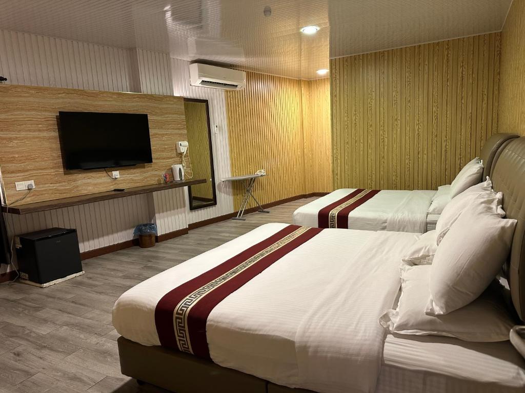 スレンバンにあるSS Hotel Serembanのベッド2台と薄型テレビ付きのホテルの部屋