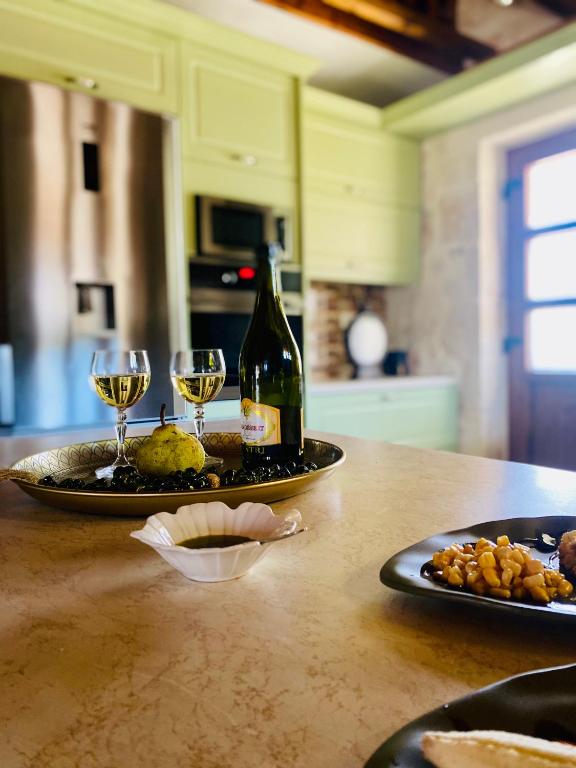 a table with two glasses and a bottle of wine at La Casa Del Sole in Agios Leon