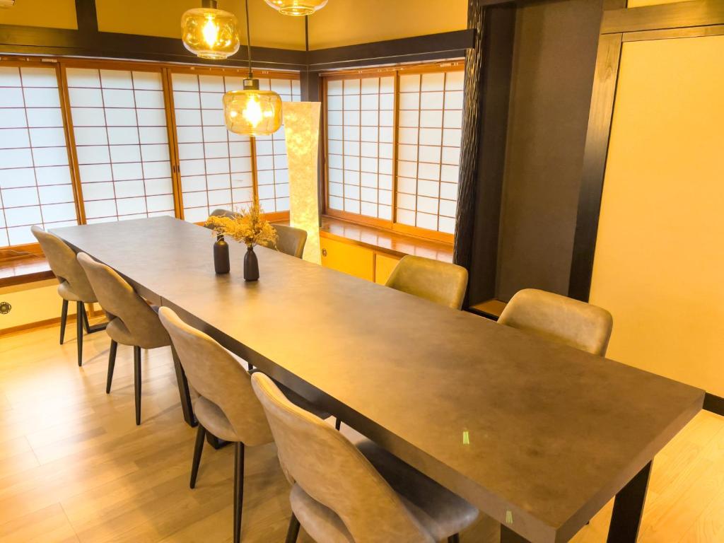 ein Esszimmer mit einem großen Tisch und Stühlen in der Unterkunft 自然豊かな古民家豪邸 最大12名まで可 大人数に最適可で アクセス良好な 菱閣 in Fujikawaguchiko