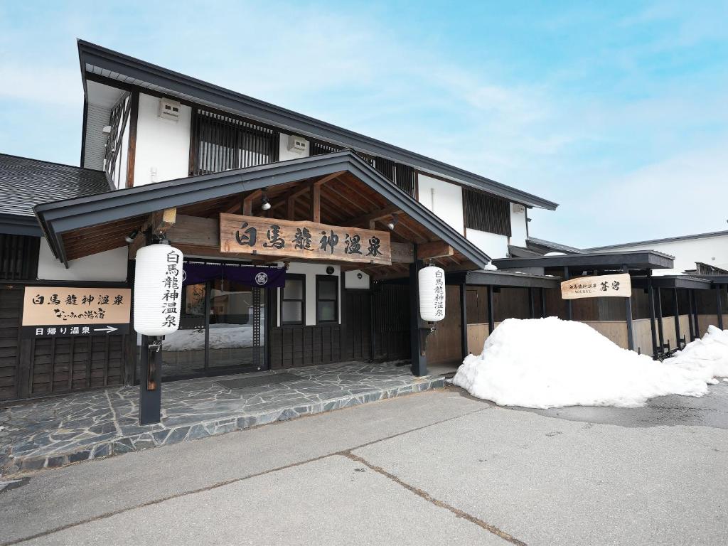 a building with signs on the front of it at Hakuba Ryujin Onsen in Hakuba