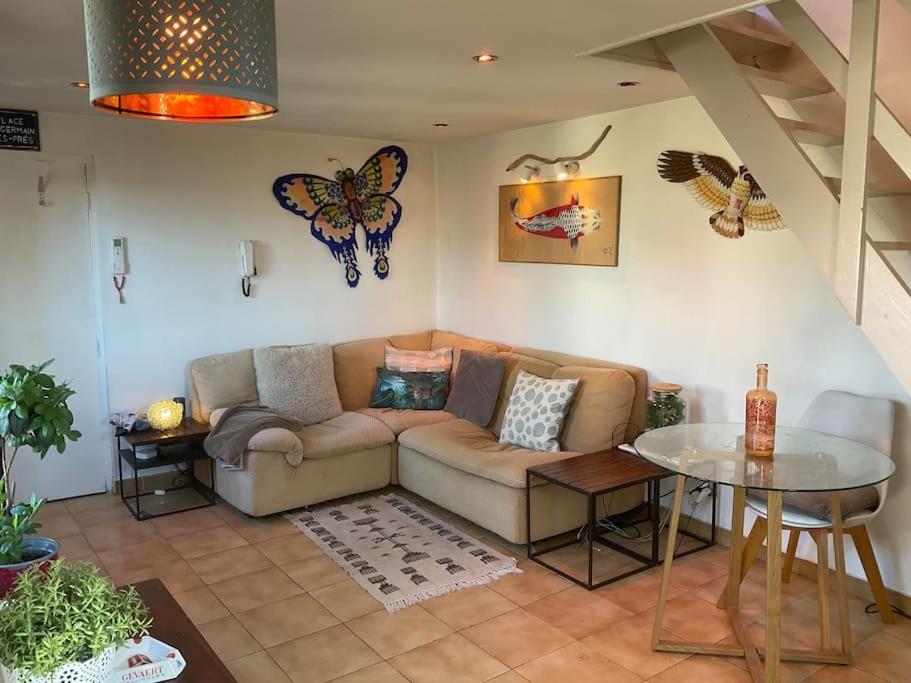 un salon avec un canapé et une table en verre dans l'établissement Appartement 1 chb, calme, lumineux, clim, terrasse, à Avignon