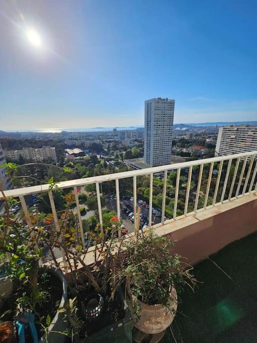 - un balcon avec des plantes en pot au-dessus d'un bâtiment dans l'établissement Magnifique T3 vue mer Stade Vélodrome calanques, à Marseille