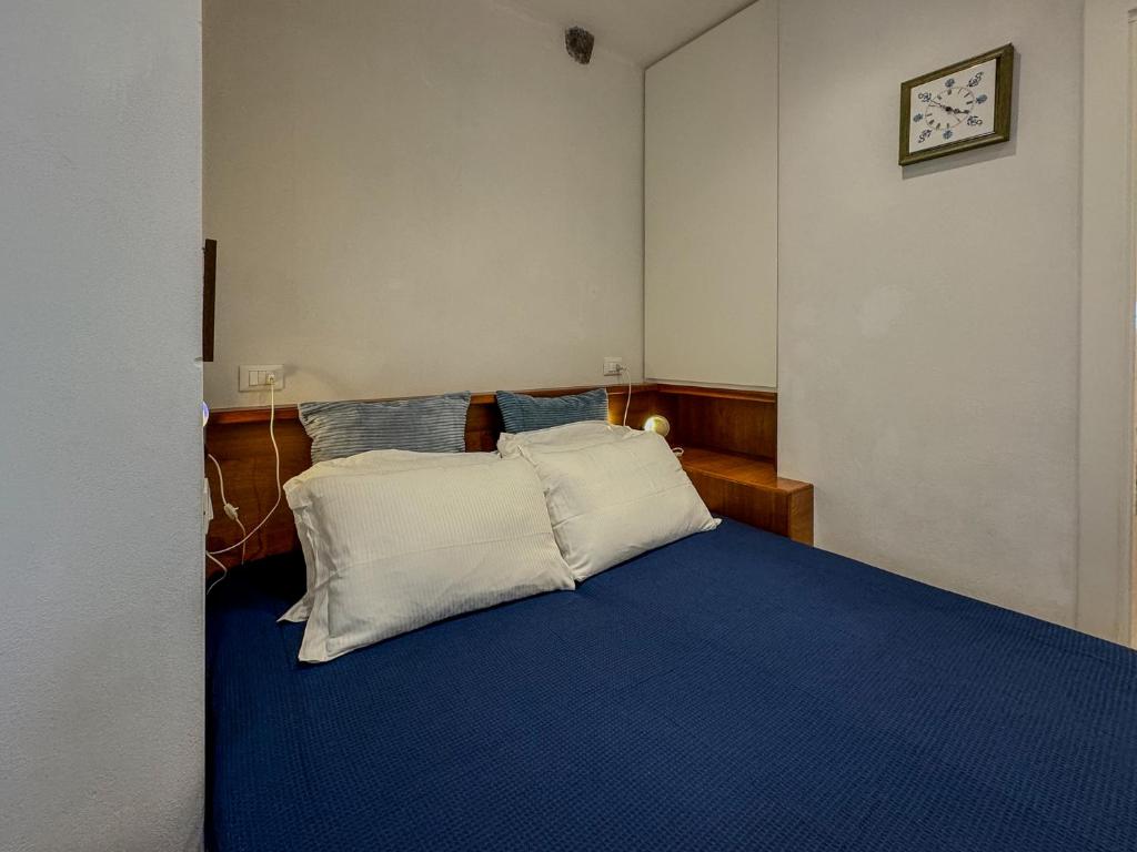 sypialnia z niebieskim łóżkiem i dwiema poduszkami w obiekcie Il Sogno di Annetta w mieście Portovenere