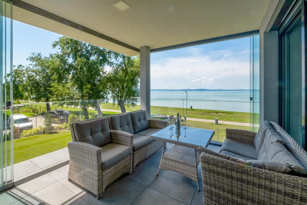 a patio with a table and chairs and a view of the ocean at MyFlat Casa Luxury Apartment in Siófok
