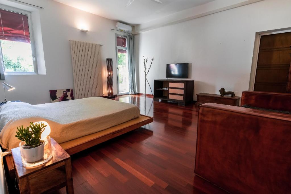 フェラーラにあるBabette Roomのベッドとテレビのある寝室