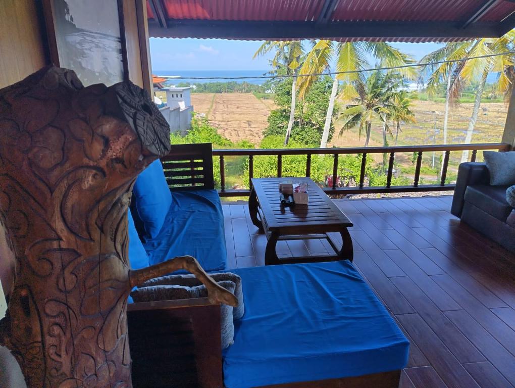 a living room with a couch and a table on a balcony at Kirra's Beach House in Pulukan