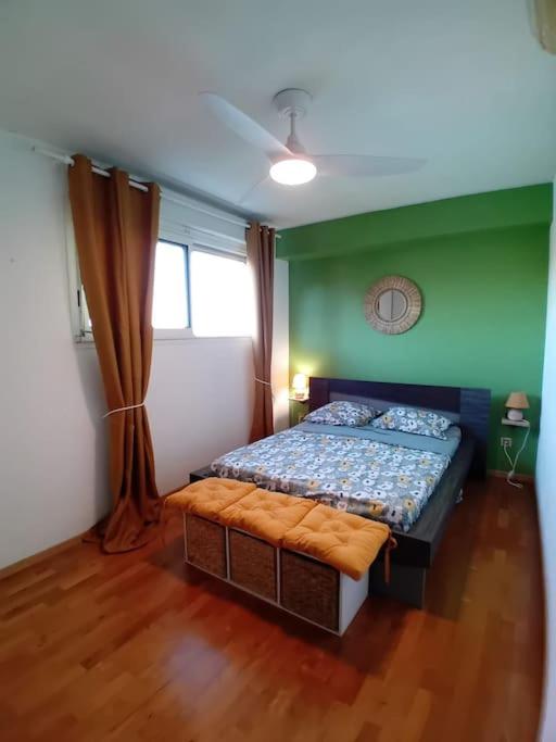 ein Schlafzimmer mit einem Bett in einem Zimmer mit grünen Wänden in der Unterkunft La longue vue in Les Avirons