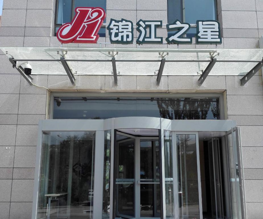 a building with a sign above a revolving door at Jinjiang Inn Xi'ning Wanda Plaza in Xining