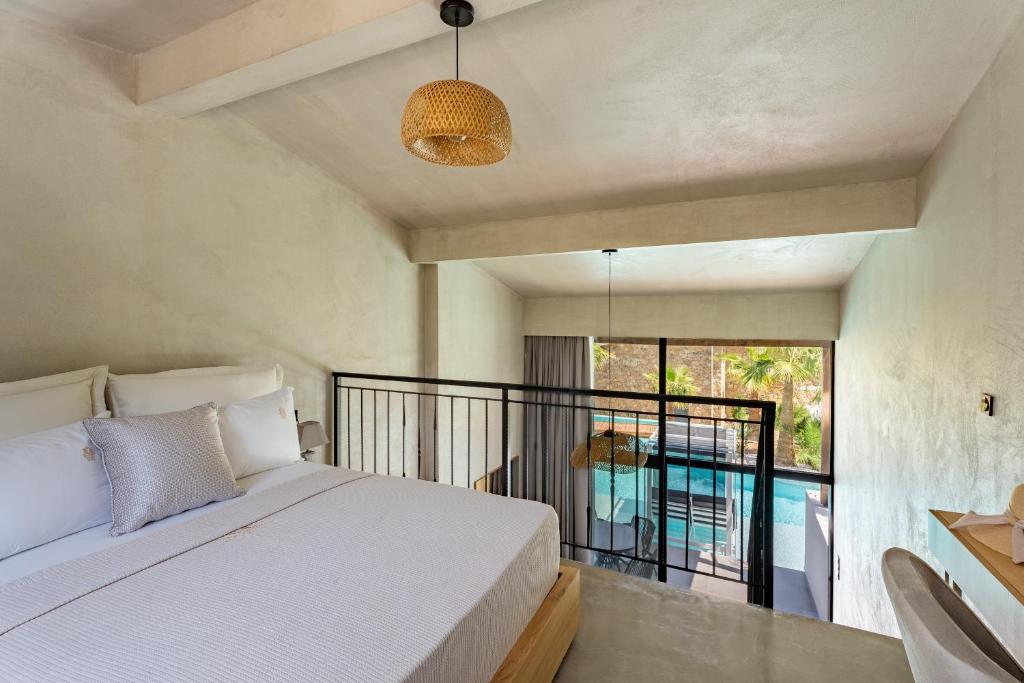 a bedroom with a bed and a balcony at Kallithea Village hotel in Kallithea Halkidikis