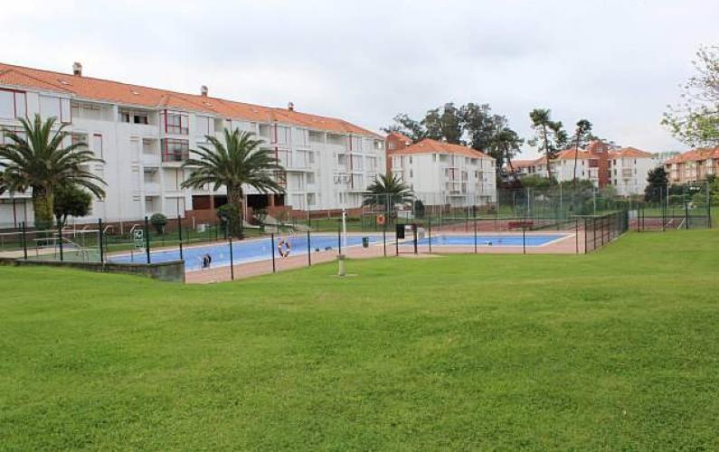 una piscina en un parque junto a un edificio en Noja, Piso a 500 m de playa en urbanización tranquila y rodeada de naturaleza, en Noja