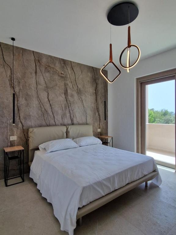 a bedroom with a large bed and a large window at Il Crepuscolo Marispica in Santa Maria Del Focallo