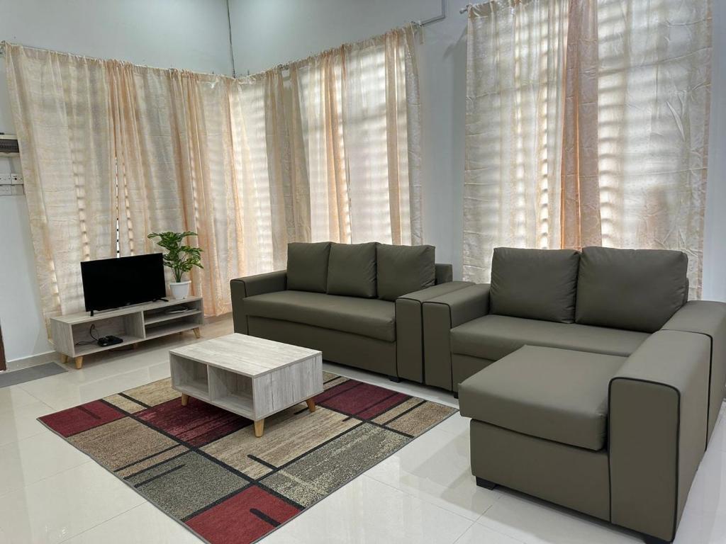 a living room with a couch and a coffee table at Homestay Kemaman Fyna08 Semi-D, 4 Bedrooms Dekat Pantai Kijal in Kijal