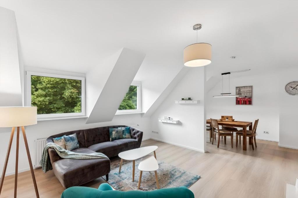 a living room with a couch and a table at Aarper Boutique Apartment I Messe, Airport, Netflix & Forest in Düsseldorf