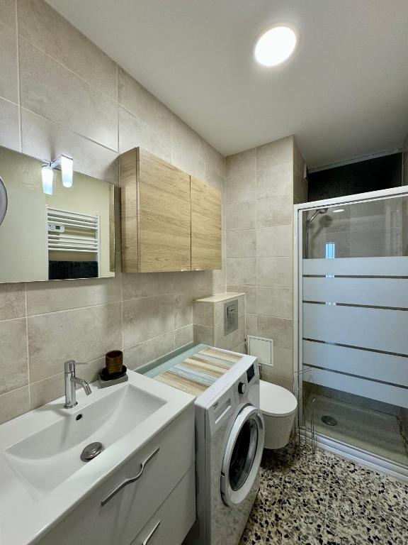 une salle de bain avec un lavabo et une machine à laver dans l'établissement superbe t2 200 m de la plage 4SUF502, au Barcarès