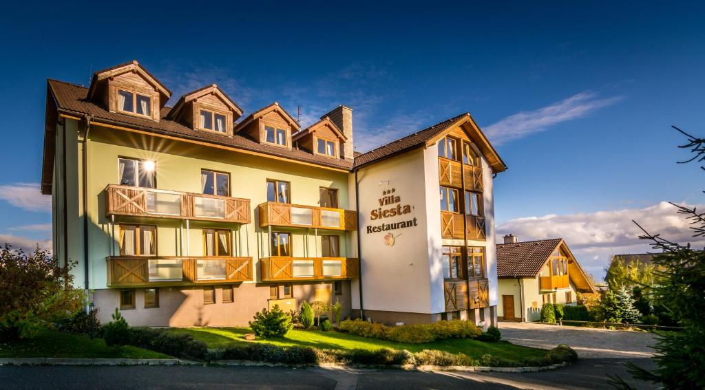 a hotel building with a sign on the side of it at Hotel Villa Siesta in Vysoke Tatry - Novy Smokovec