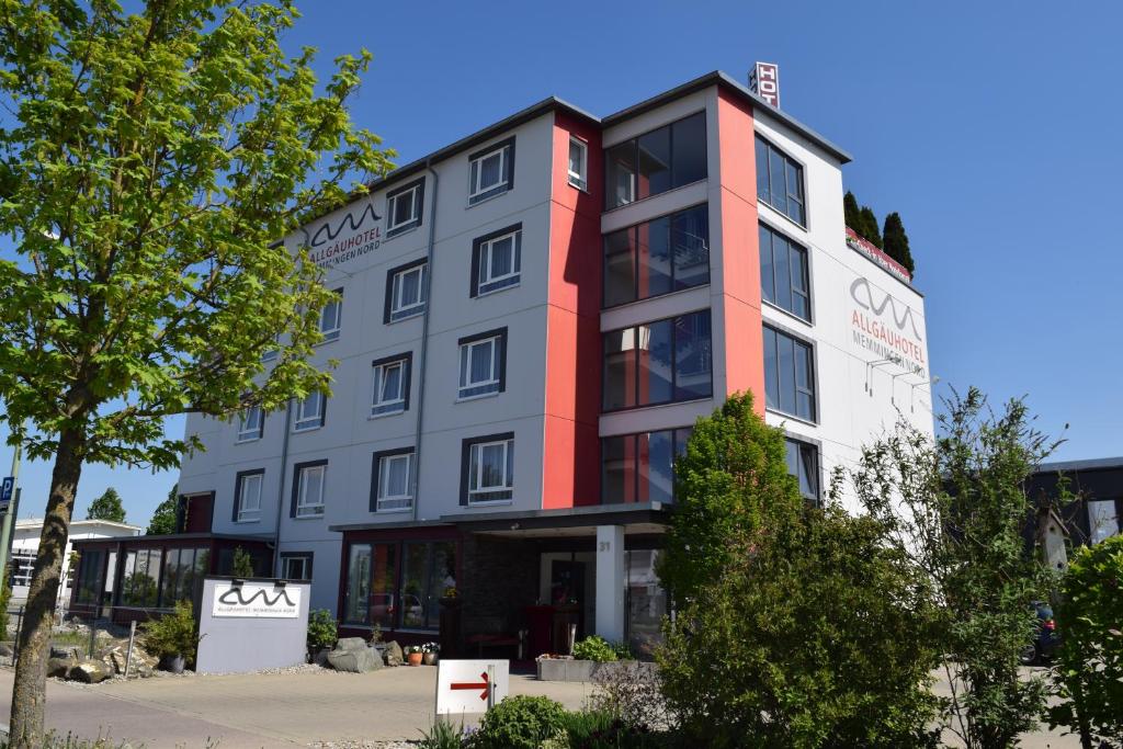 an apartment building with a red and white facade at Allgäuhotel Memmingen Nord in Memmingen