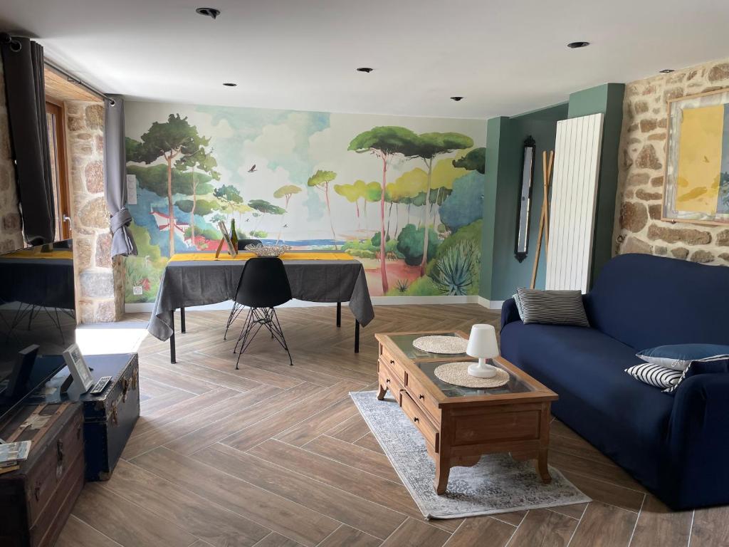 un salon avec un canapé bleu et une table dans l'établissement Gîtes d Izel N1 entre terre et mer prés d'un golf, à Ploemel