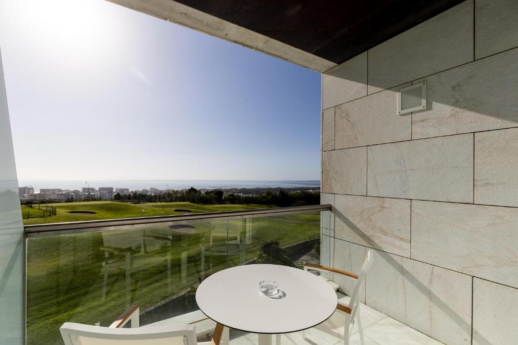 a dining room with a table and a large window at Crowne Plaza - Caparica Lisbon in Costa da Caparica