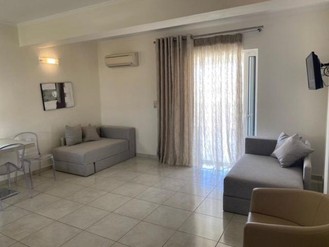 a living room with a couch and a chair at Ammos Suites in Platy