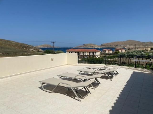 a row of lounge chairs sitting on a patio at Ammos Suites in Platy