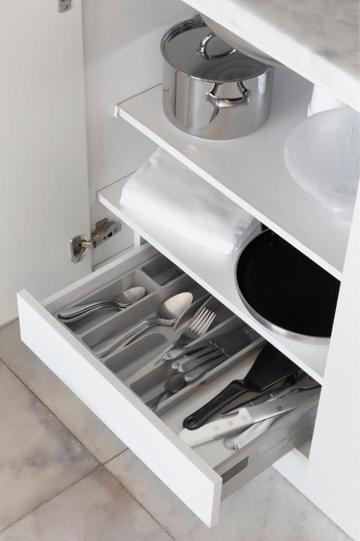 a kitchen with white cabinets and a sink at Crowne Plaza - Caparica Lisbon in Costa da Caparica