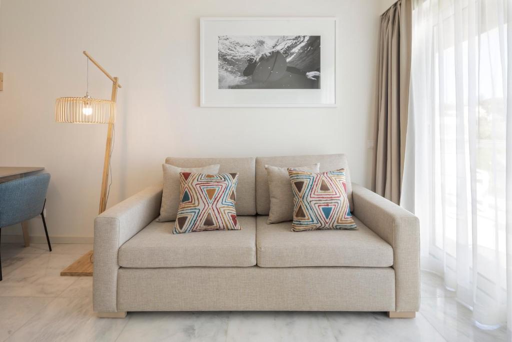 a couch with pillows in a living room at Crowne Plaza - Caparica Lisbon in Costa da Caparica