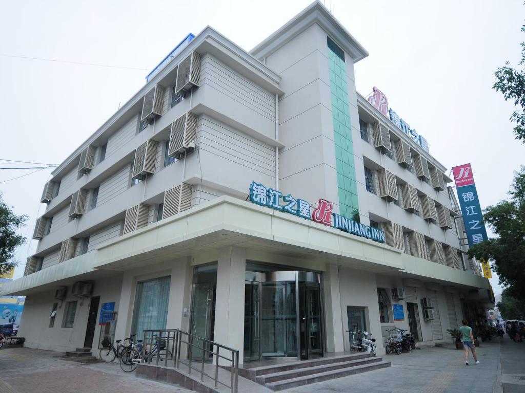 a large white building with a sign on it at Jinjiang Inn Dezhou Railway Station in Dezhou