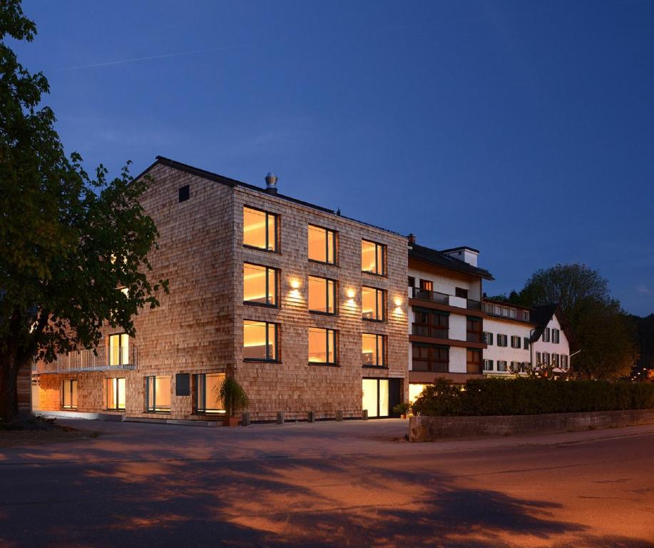 ein großes Backsteingebäude mit eingeschaltetem Licht in der Unterkunft Hotel Hoher Freschen in Rankweil