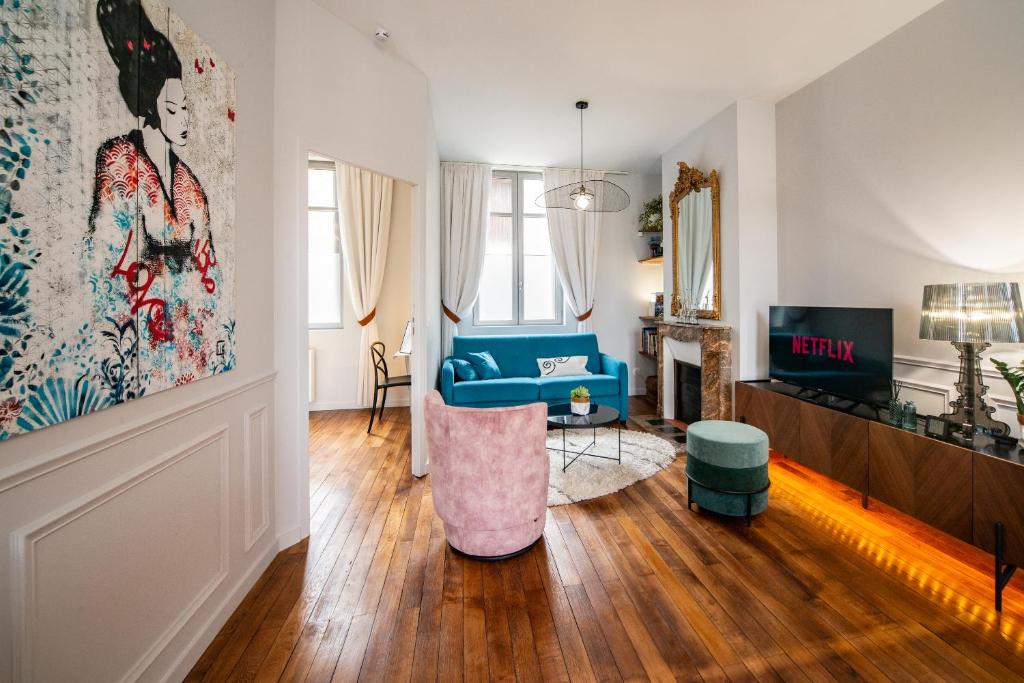 un salon avec un canapé bleu et une télévision dans l'établissement Le Jardin De Guilbaud - Hypercentre - Netflix, à Tours