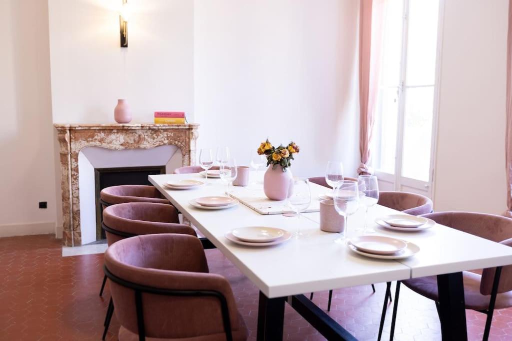 - une table avec des chaises et une table blanche avec des verres à vin dans l'établissement Grand Standing Appartement, à Marseille