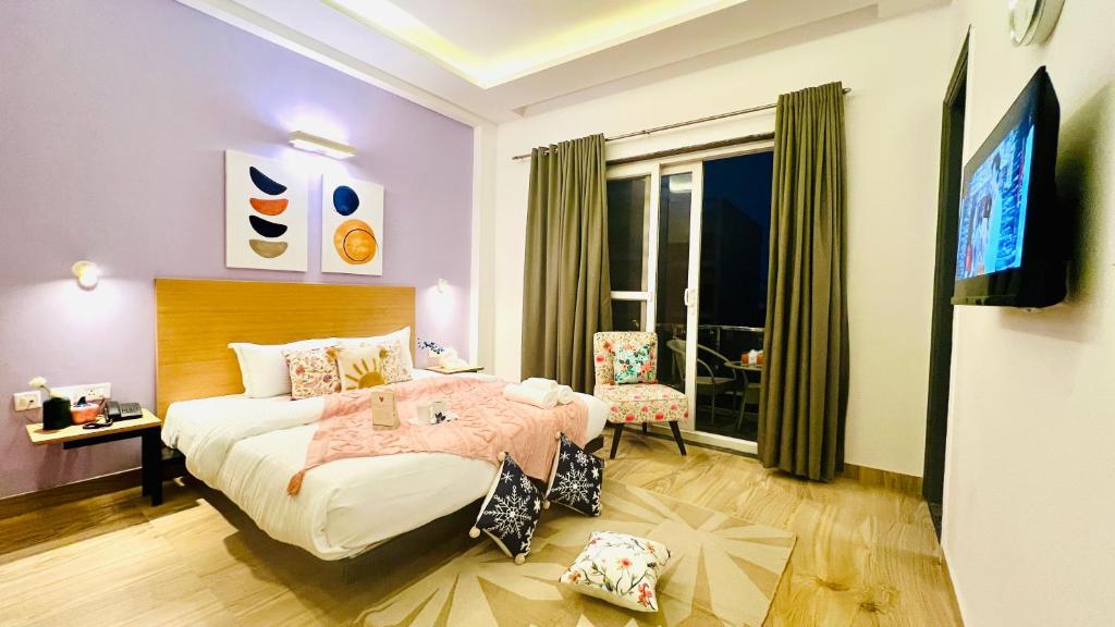 a bedroom with a bed and a television in it at ZEN Medicity - Boutique Hotel Gurgaon in Gurgaon