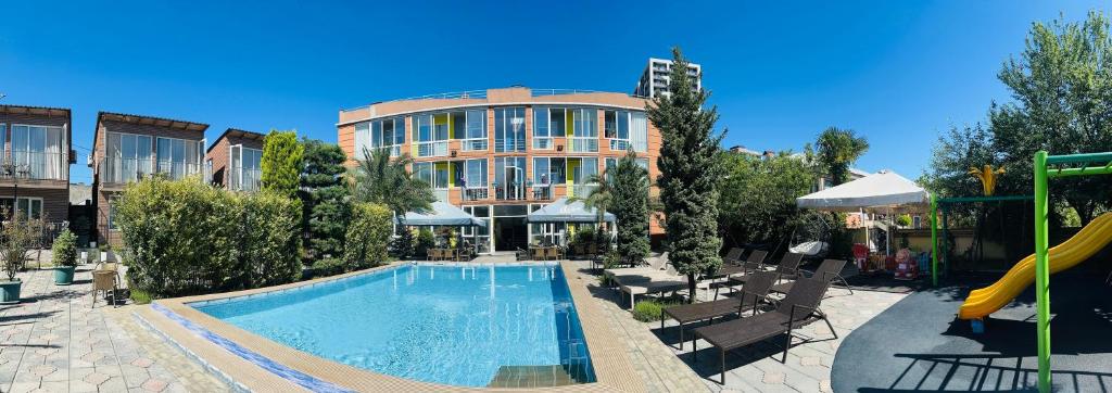 a swimming pool in front of a building at Hotel Buta in Batumi
