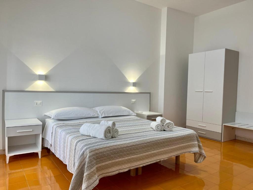 una camera da letto con un letto grande con asciugamani sopra di Appartamenti Antonio a Tropea
