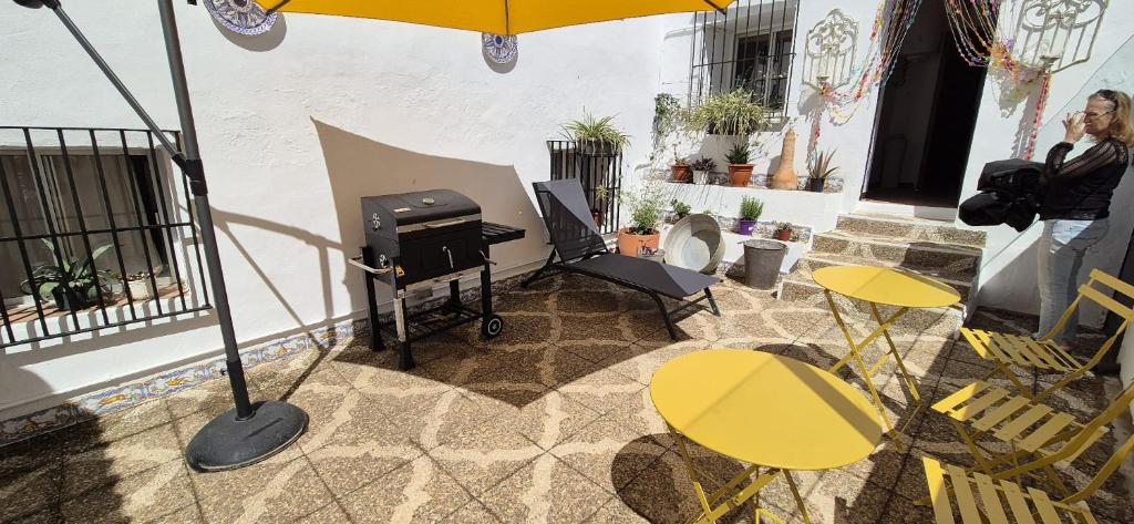 eine Außenterrasse mit Grill, Tischen und Sonnenschirm in der Unterkunft La Fresquita, Castaño del Robledo in Castaño de Robledo
