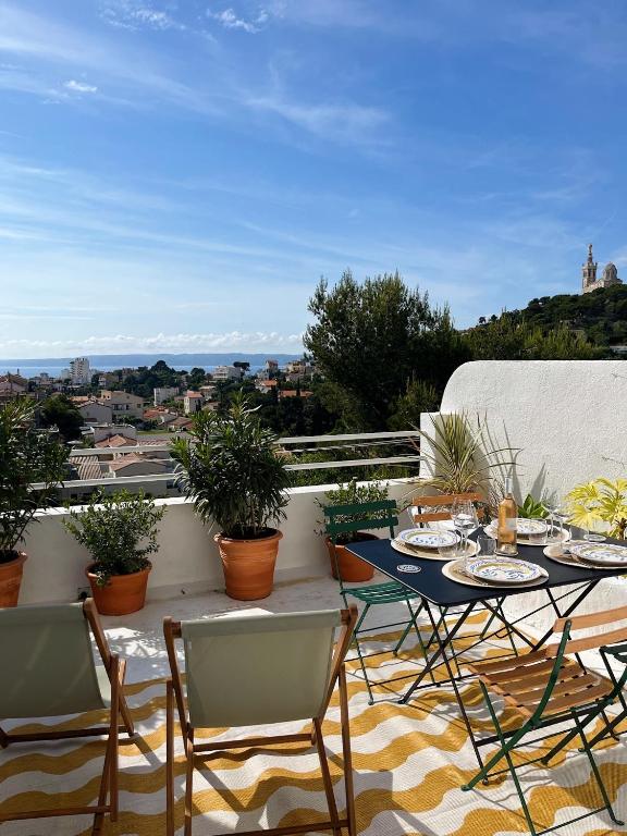 un patio avec une table et des chaises sur un balcon dans l'établissement Charmant studio-terrasse vue mer, à Marseille