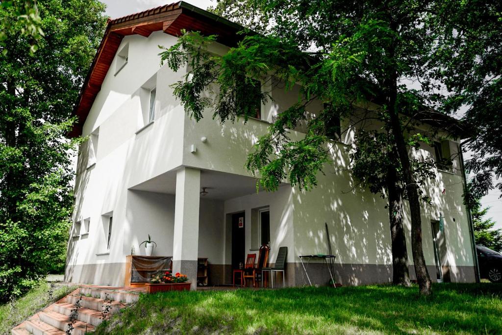 a white house with chairs on the porch at Leśny Dworek in Żary