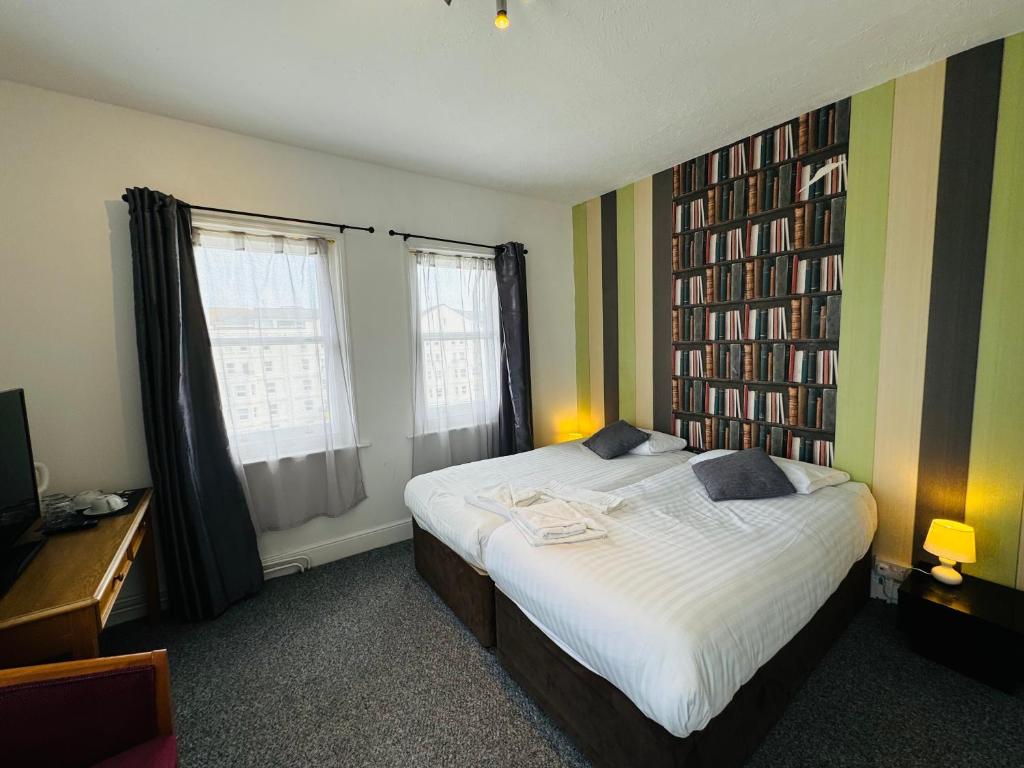 - une chambre avec un lit et des étagères dans l'établissement Carlton Court Hotel Eastbourne, à Eastbourne