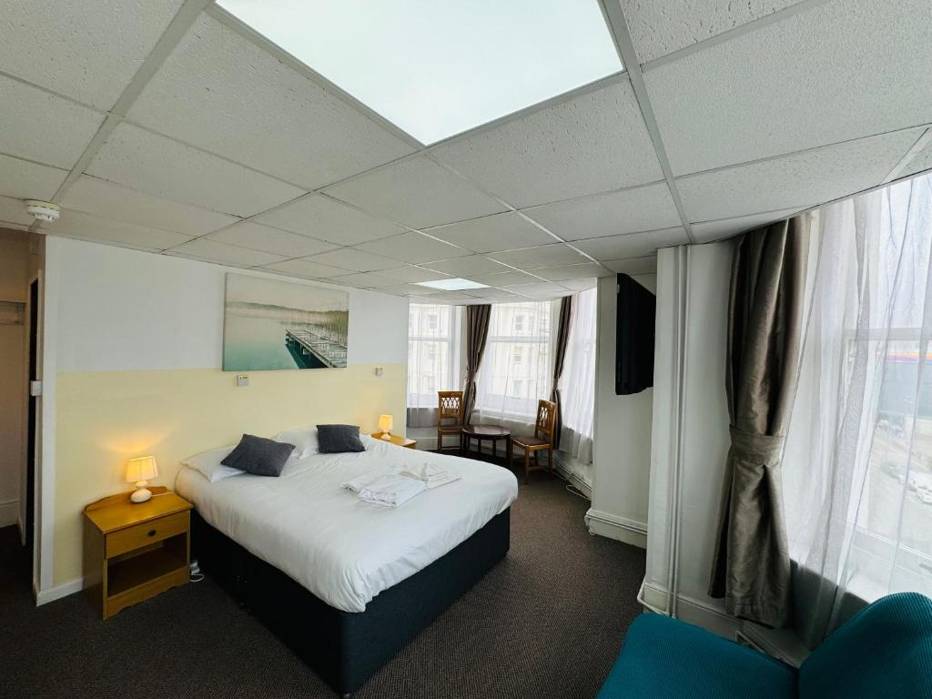 Habitación de hotel con cama y ventana en Carlton Court Hotel Eastbourne en Eastbourne